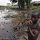 A boy stands near oil slick polluting a farmland in Ibeno village in Nigeria’s Akwa Ibom State